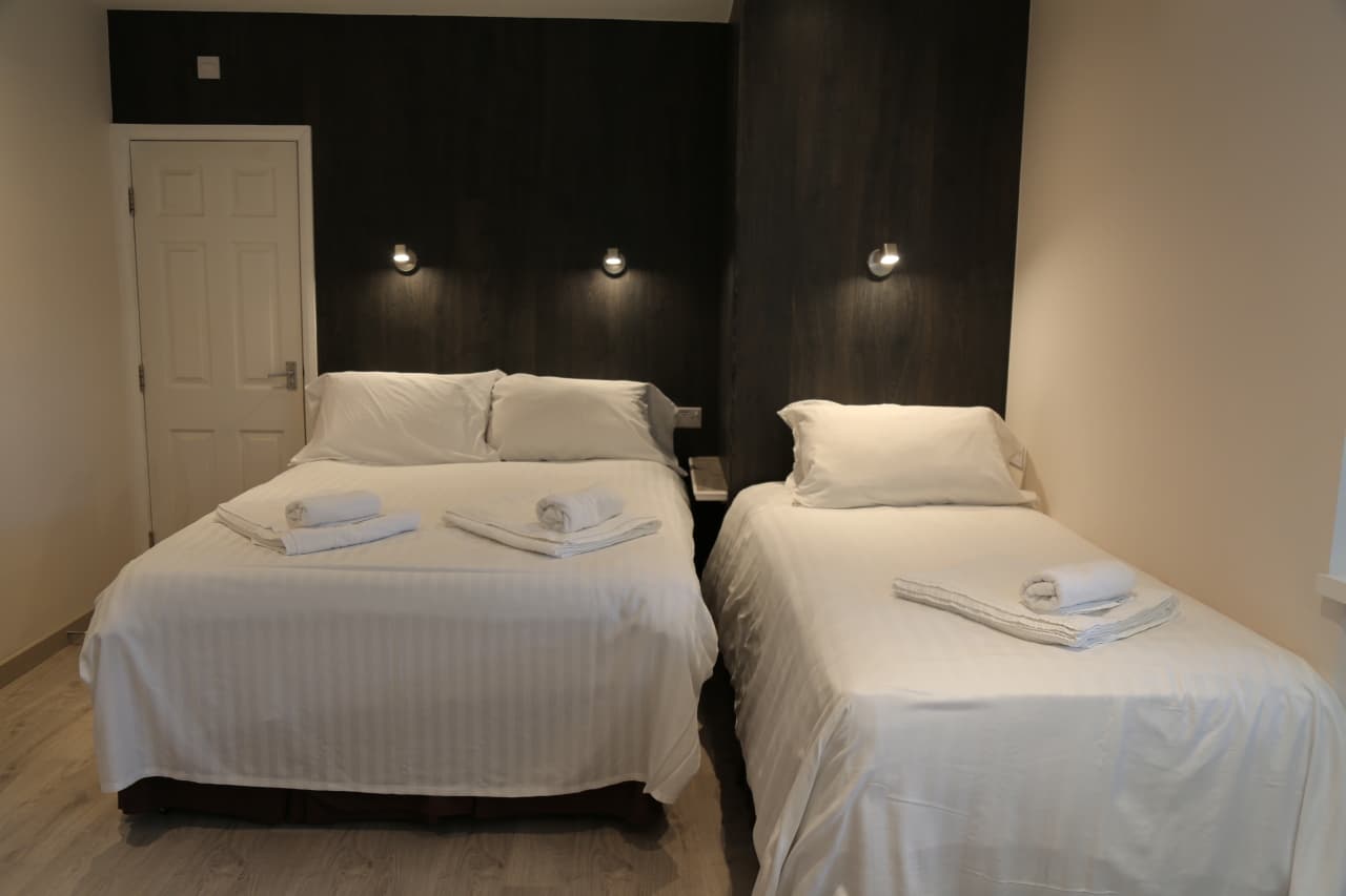 Twin room with two single beds against a dark feature wall