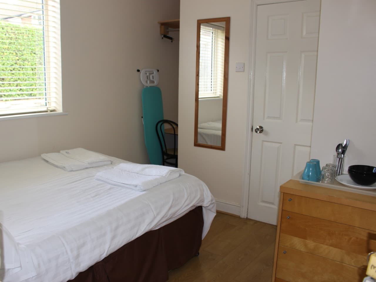 Room with a double and a single bed, a mirror and a bedside chair