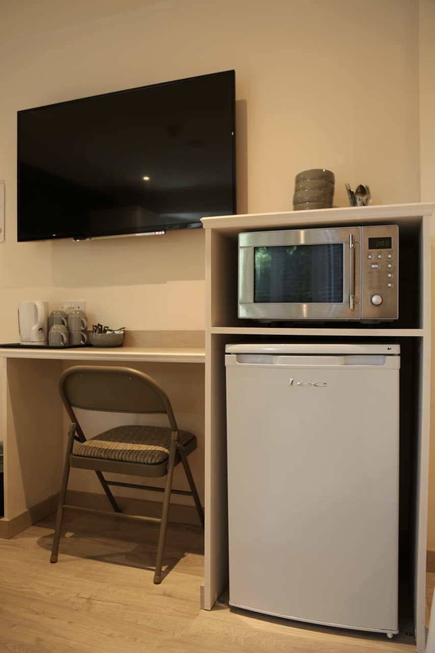 Kettle, microwave and fridge in a room's kitchenette corner
