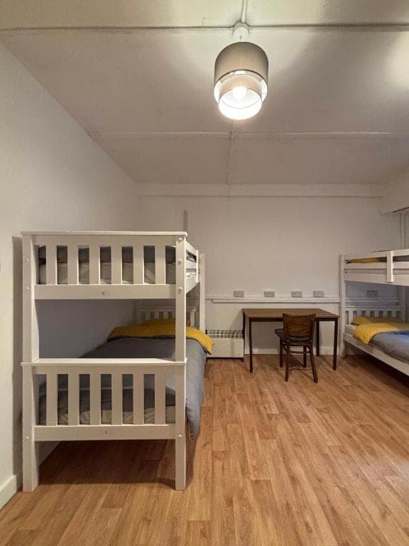 Dormitory with bunk beds, a desk and chairs
