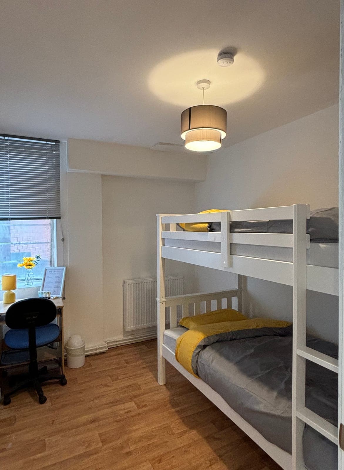 Twin room with a desk and chair beside the beds